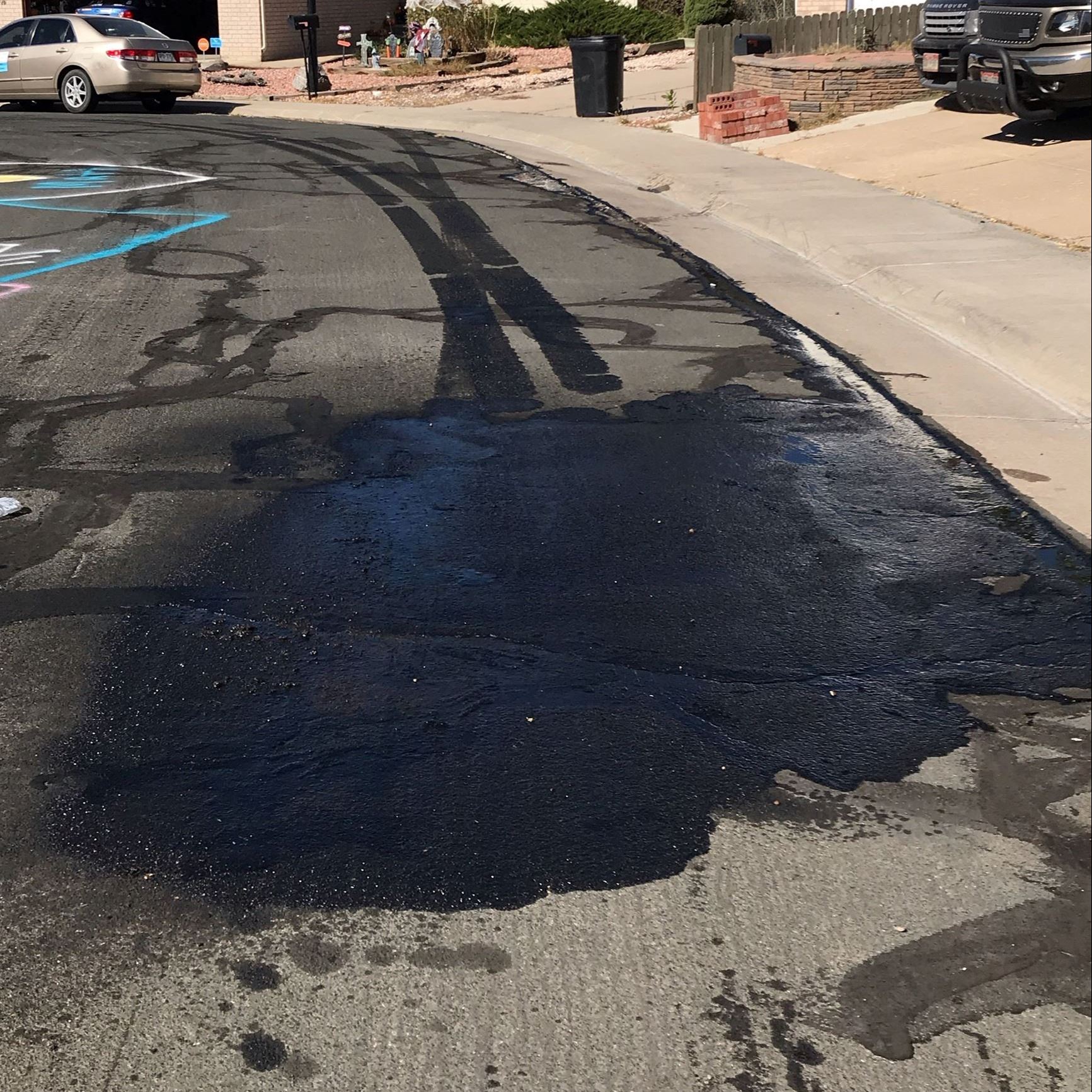 A large oil stain in the road form a leaking garbage truck.