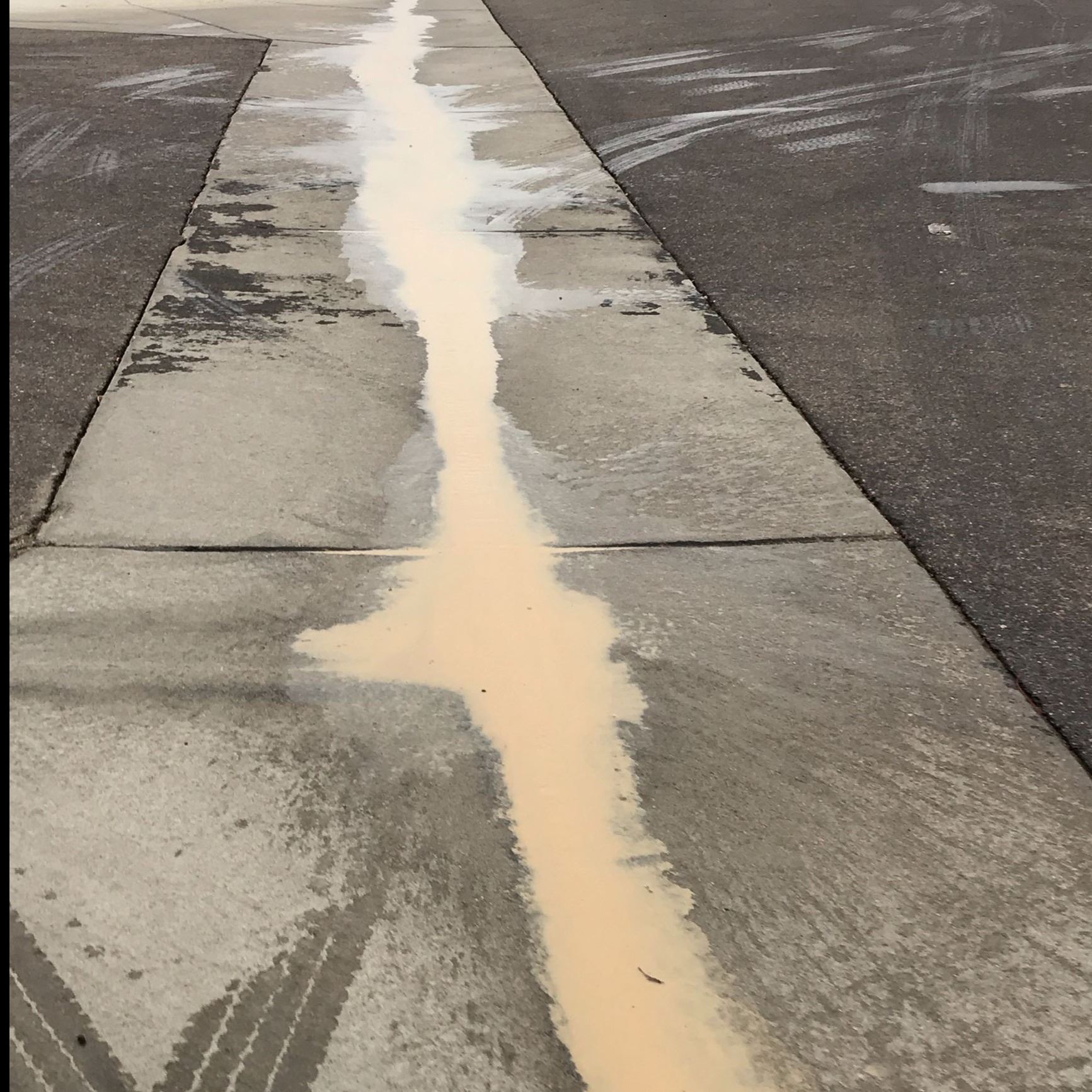 Sediment loaded wastewater from boring operations in the cross pan of a road.