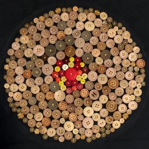Circle of buttons with red and yellow in the middle and brown wood on the outside. 