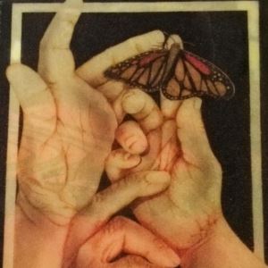 Painting of three hands with a butterfly perched on one of them. 
