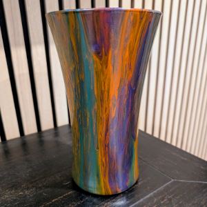 Multicolored vase with oranges, greens, and purples. 