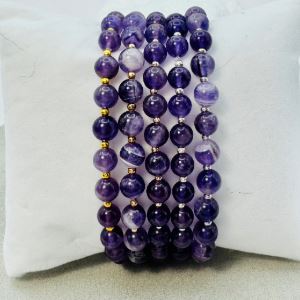 Photograph of a handmade bracelet with purple gemstones. 